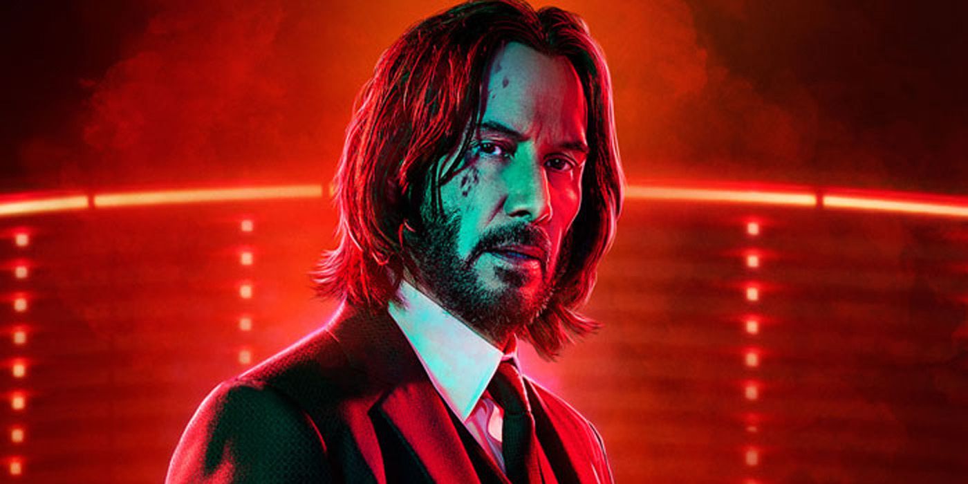 Keanu Reeves as John Wick wearing a suit and tie with blood on his face in John Wick Chapter 4