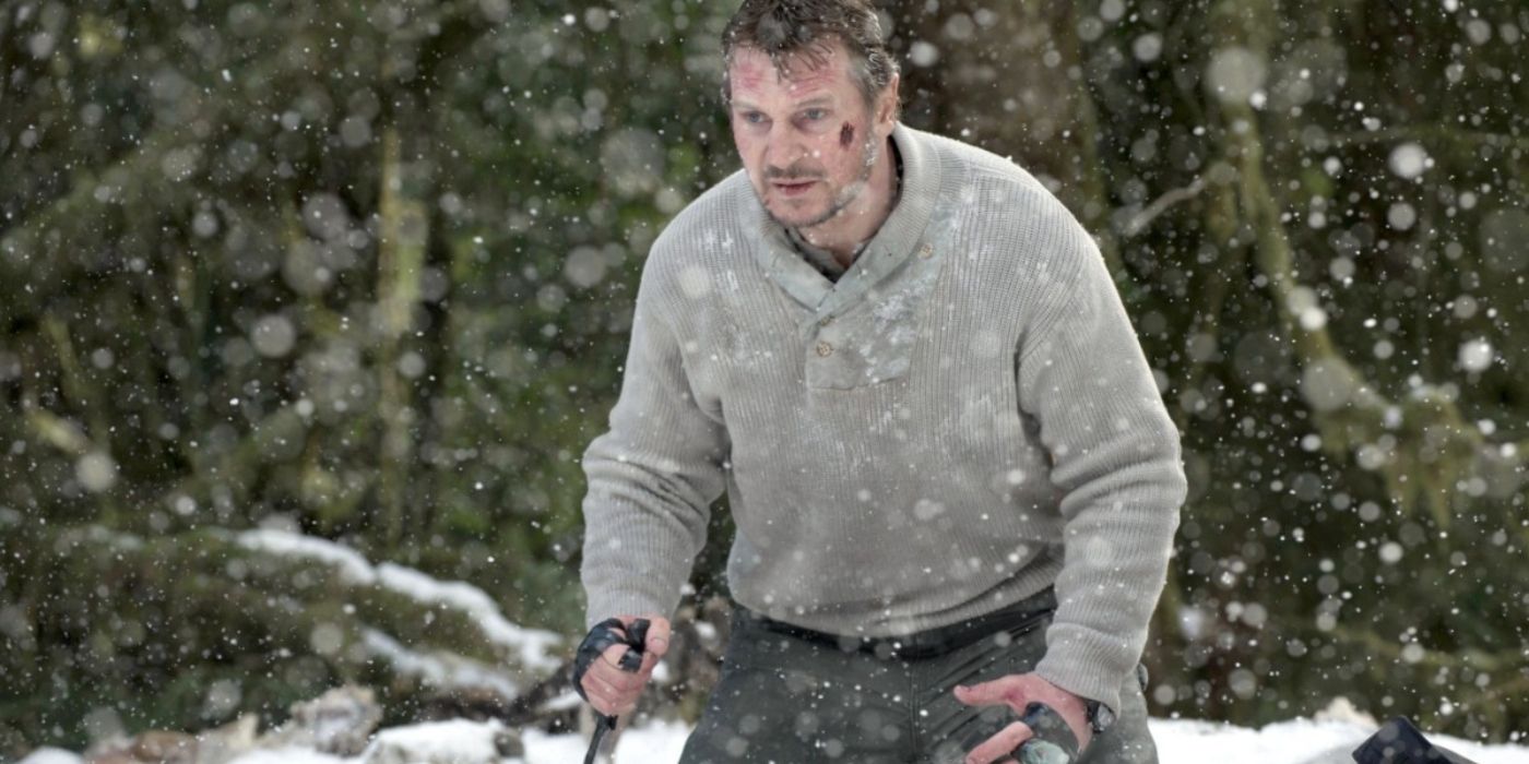 A grizzly-looking middle-aged man, armed with a knife, stands at the ready in a wintry forest.