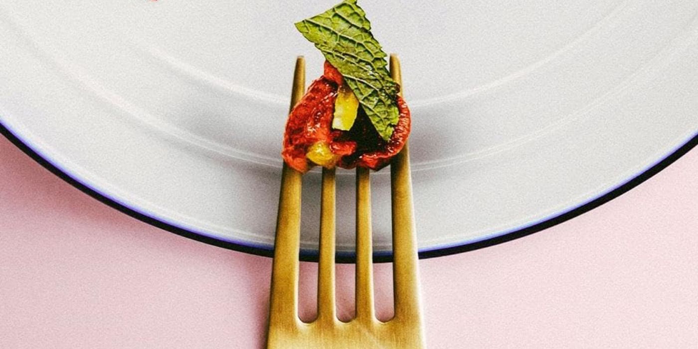 A gold fork with a cherry tomato and basil in Menus-Plaisir Les Troisgros