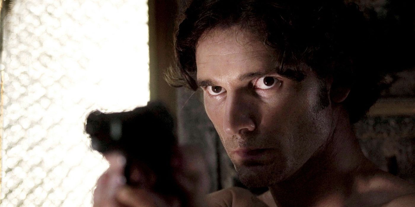 A close-up of a man pointing a gun at someone off-screen.