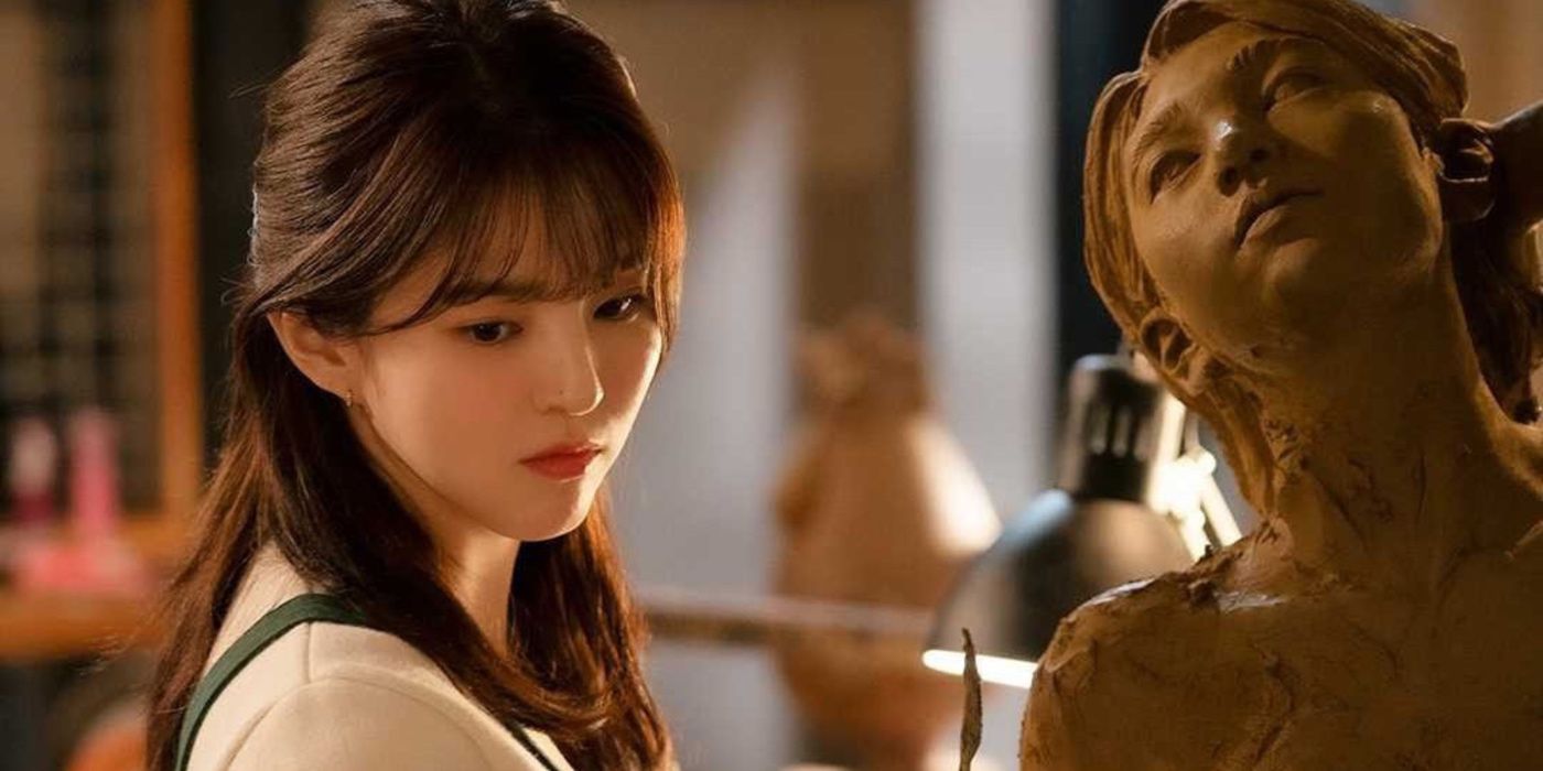 Han So-hee as Yu Na-bi looks deep in thought as she stands next to a sculpture in Nevertheless