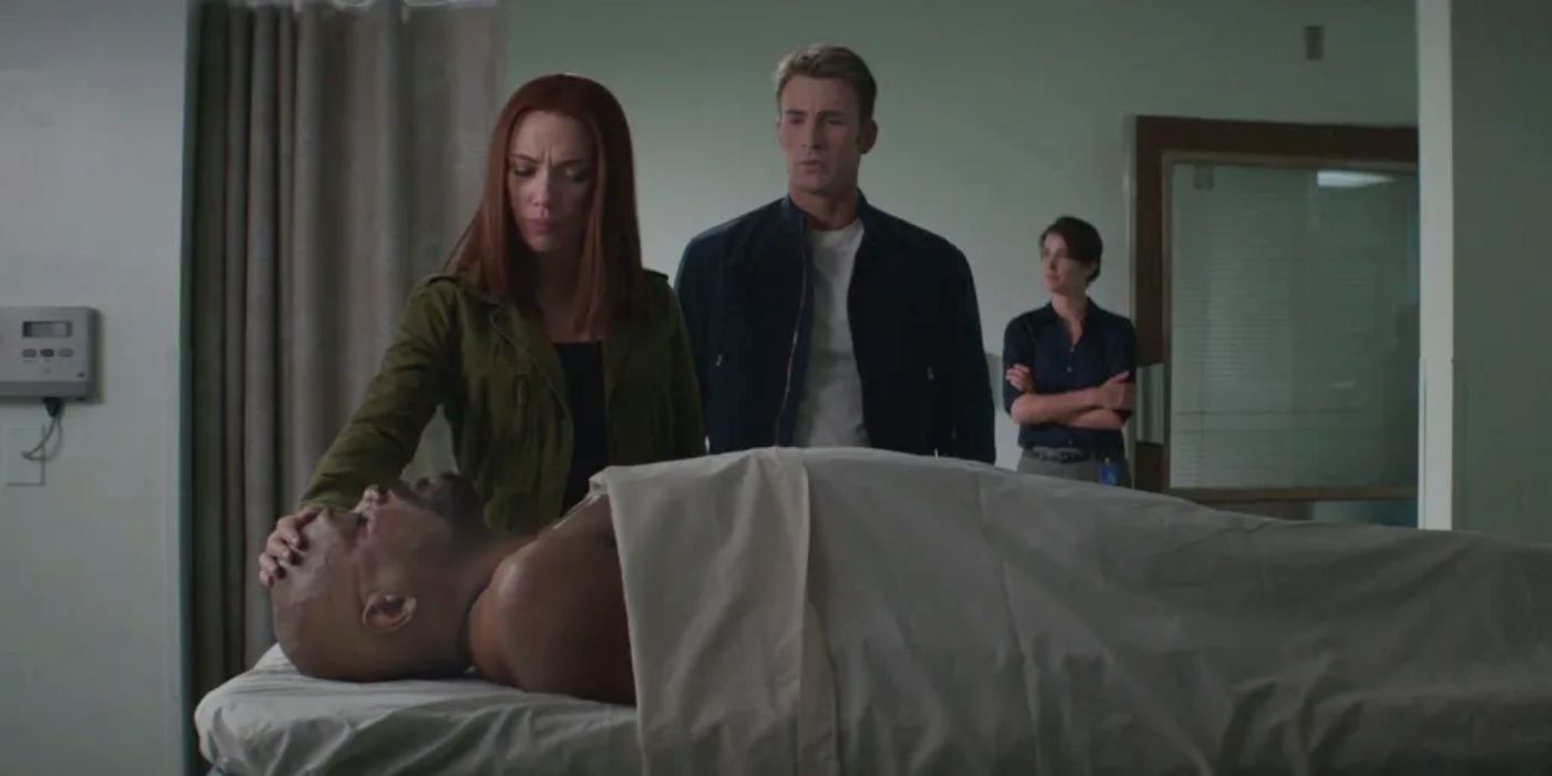 Black Widow and Captain America look down at Nick Fury's body