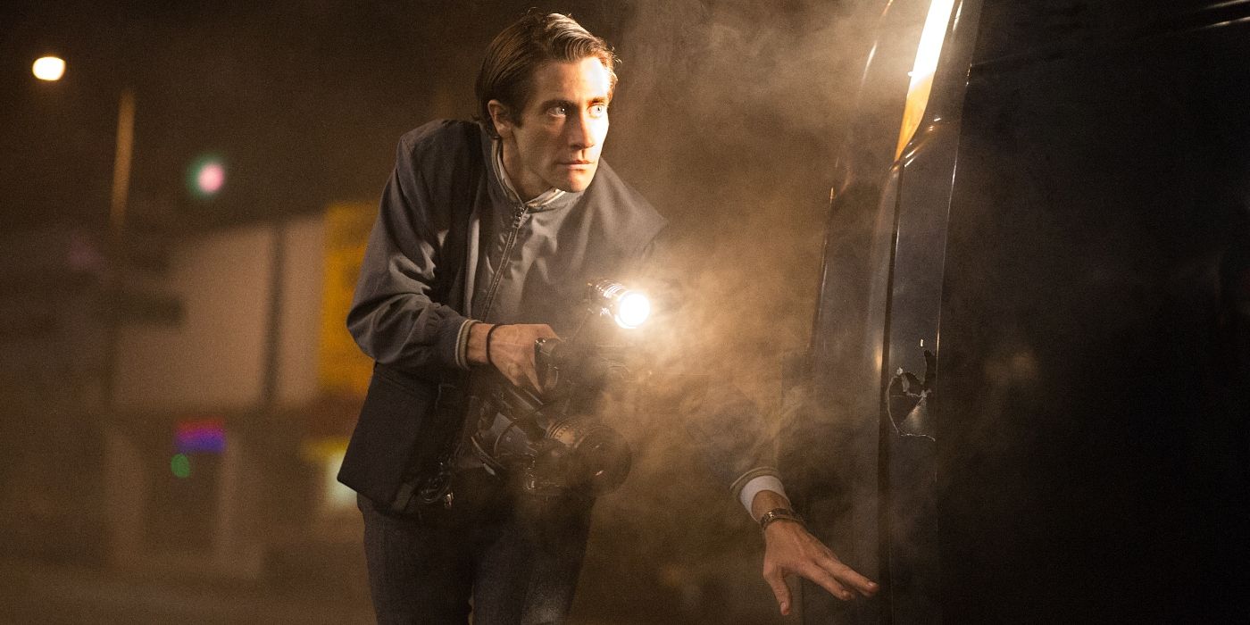 Jake Gyllenhaal hides beside a truck while using a flashlight in the film nightcrawler