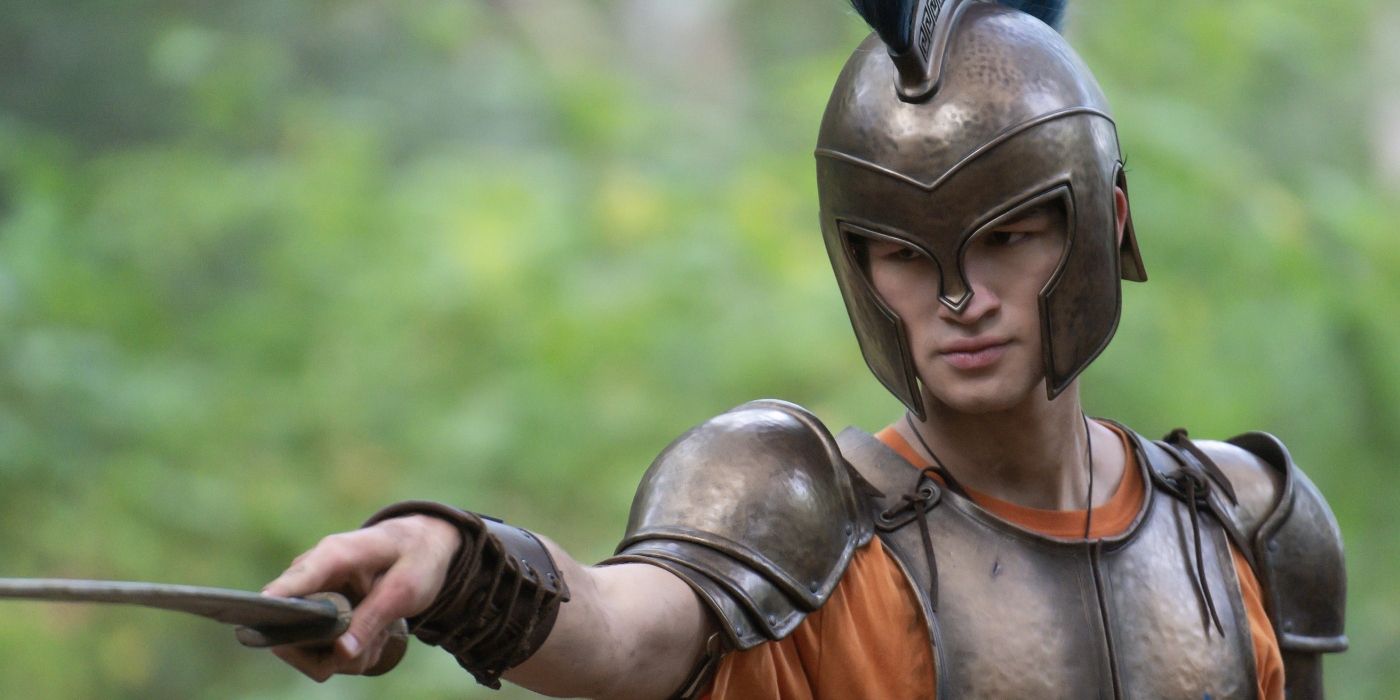 Charlie Bushnell como Luke Castellan usando uma armadura segurando uma adaga em Percy Jackson e os Olimpianos no Disney+