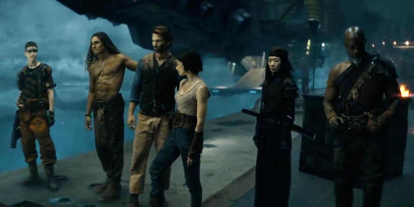 The main cast of Rebel Moon Part One standing next to a large ship preparing to take off