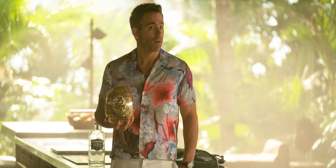 Ryan Reynolds as Nolan Booth wearing a hawaiin shirt holding a golden egg in the jungle in Red Notice
