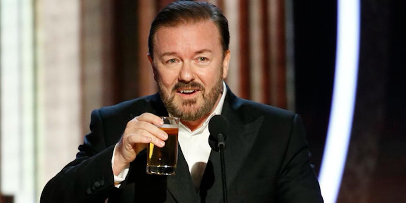 Ricky Gervais drinking while smiling on stage hosting the Golden Globes