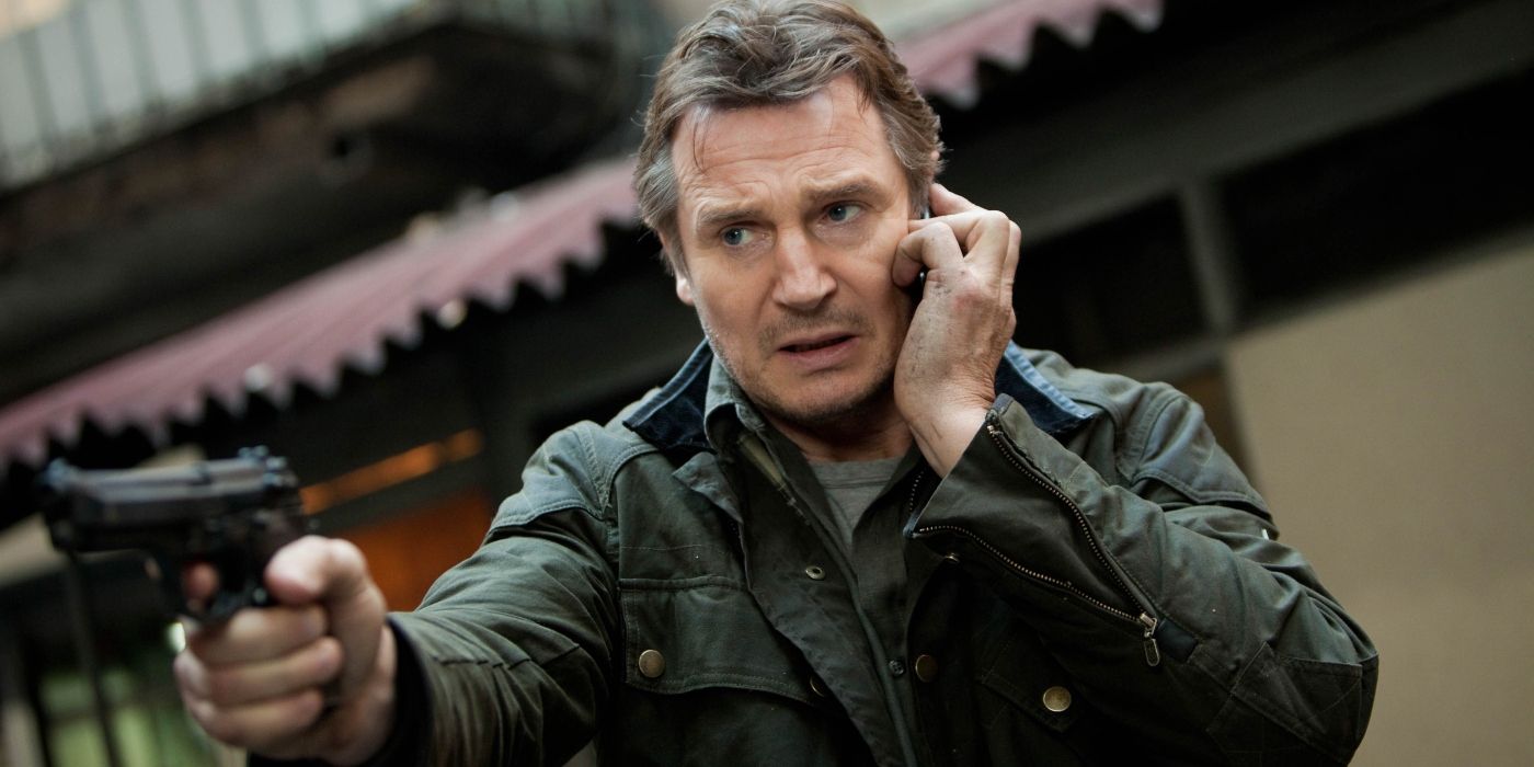 Capturado Liam Neeson Bryan Mills em um telefone celular e apontando uma arma