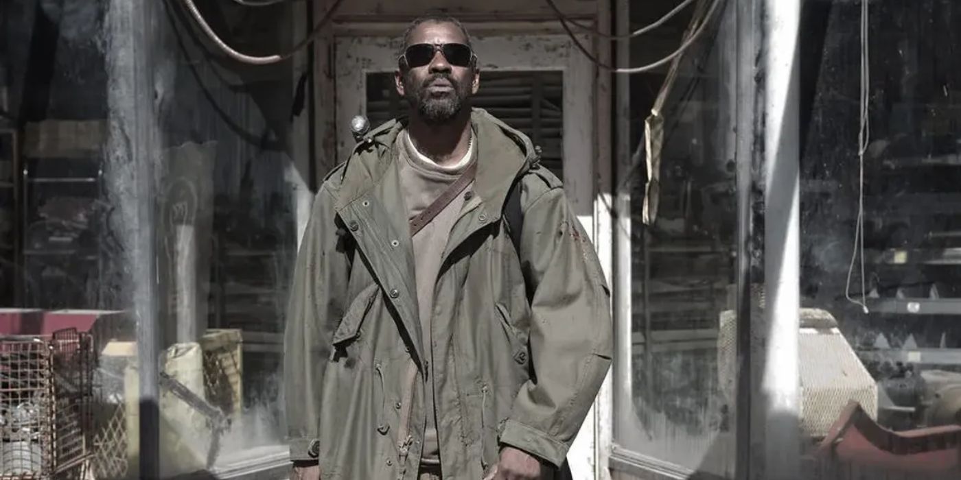 Denzel Washington as Eli in a trench coach in front of a store in The Book of Eli