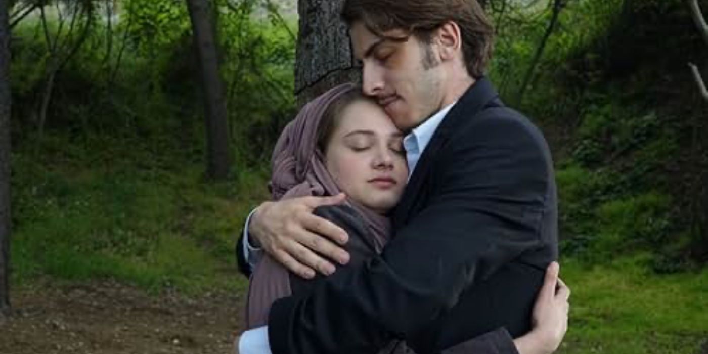 The main characters of Wounded Love embrace in a forest.