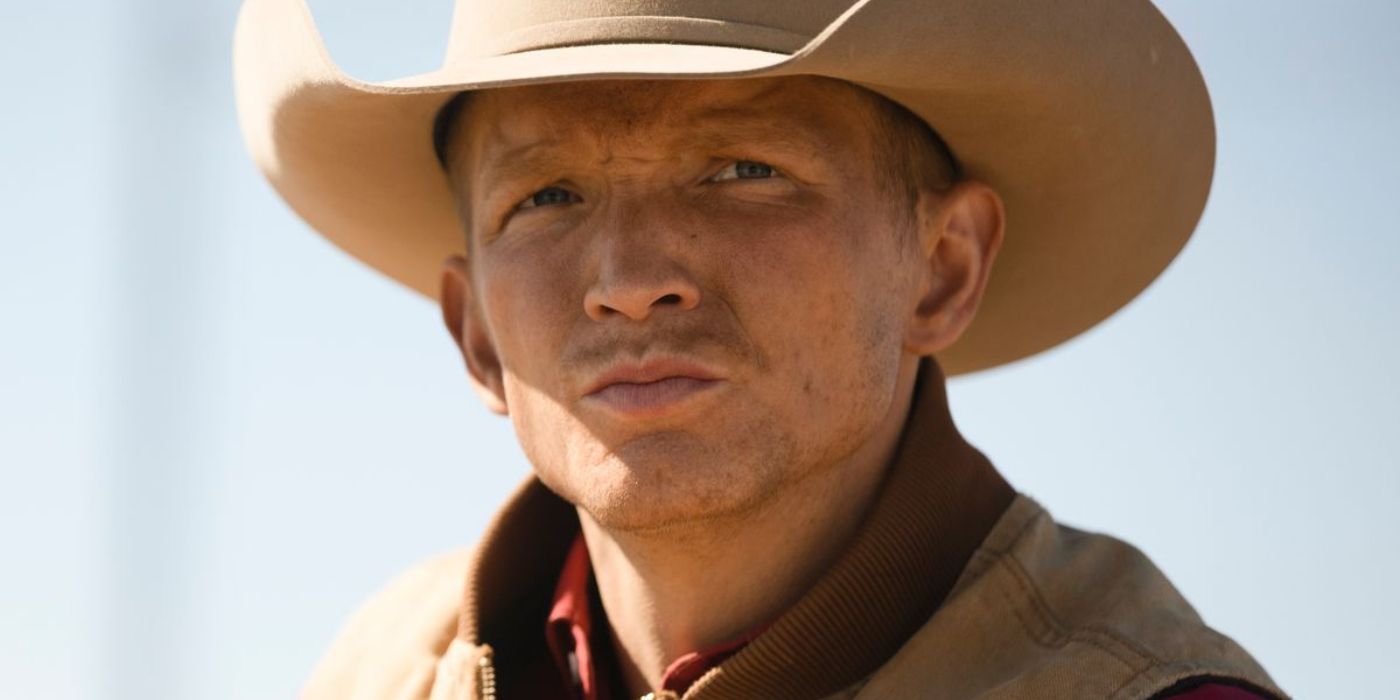 Jefferson White as Jimmy in Yellowstone wearing a cowboy hat and tan jacket looking at something in the distance.