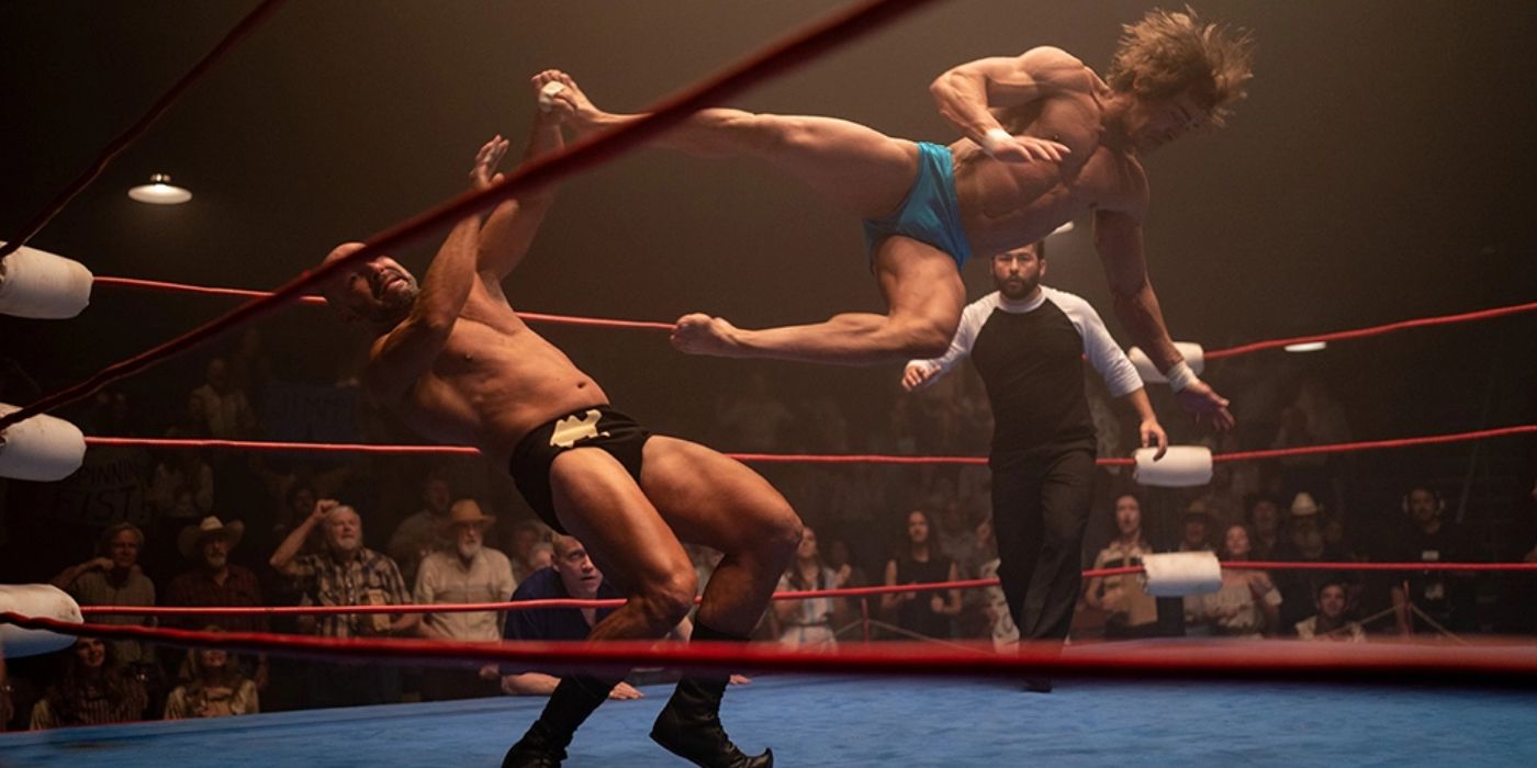 Zac Efron as Kevin Von Erich flying through the air performing a move in the ring as The Iron Claw