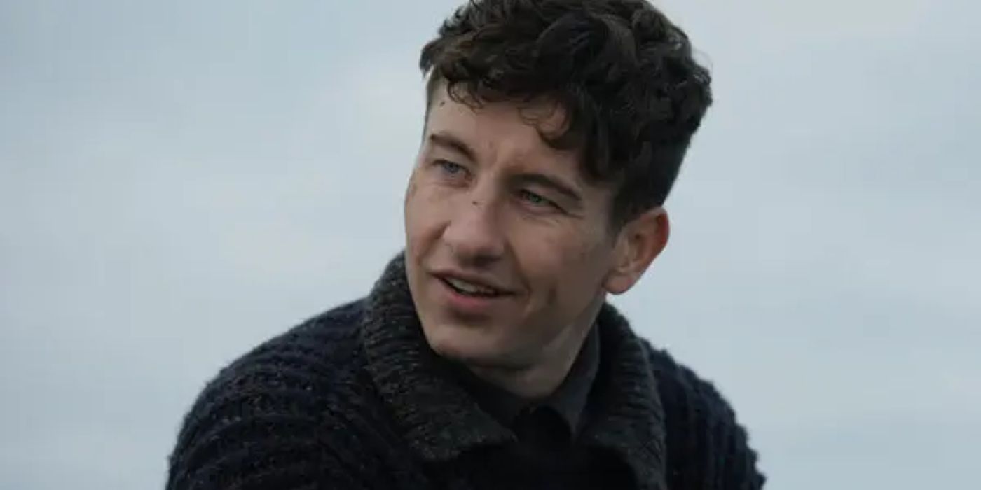 Barry Keoghan as Dominic Kearney wearing a dark sweater smiling at someone off-screen in Banshees of Inisherin