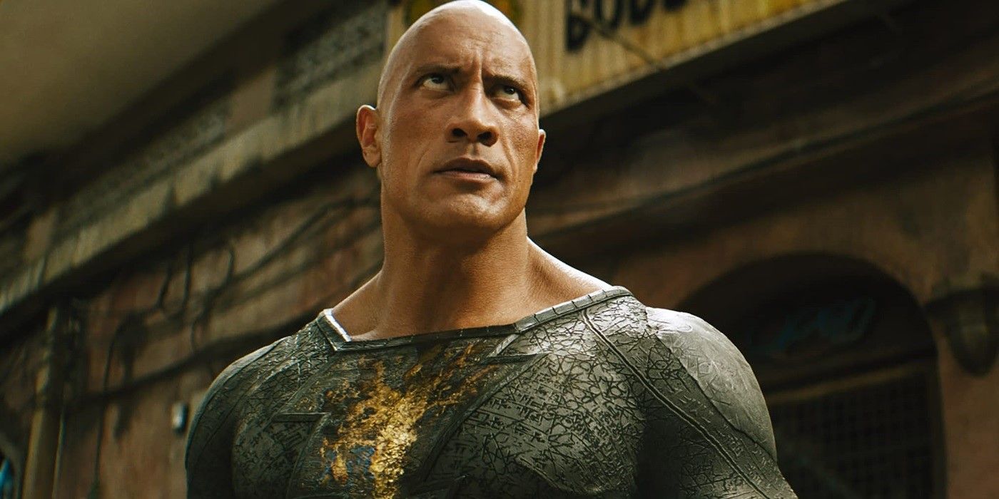 Dwayne Johnson as Black Adam wearing his black and gold suit looking at someone off-screen in Black Adam