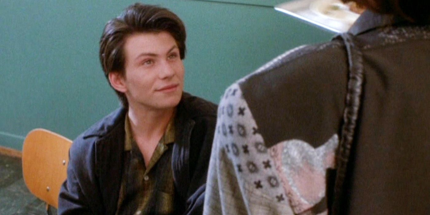 Christian Slater as JD, with slicked hair and a sly grin, in Heathers