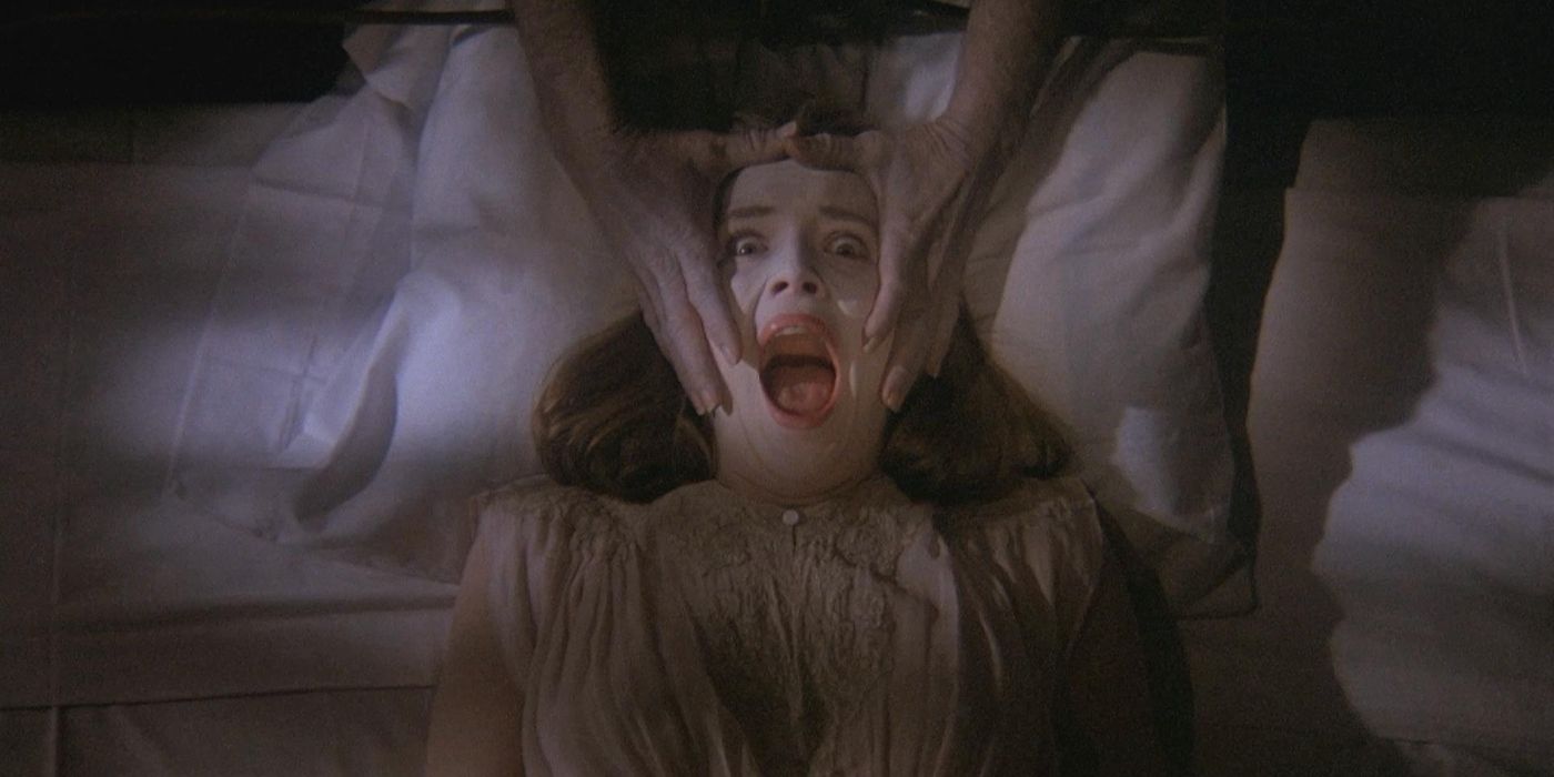 Maren Jensen as Martha, lying in bed as two hands grab her face