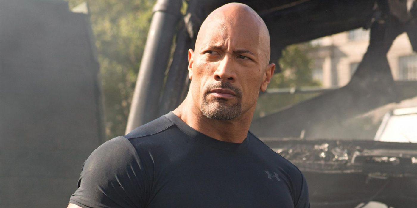 Dwayne Johnon as Hobbs wearing a tight black shirt in the Fast and Furious franchise