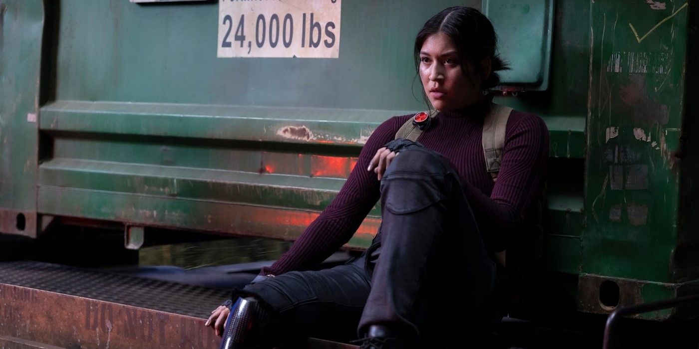 Maya Lopez (Alaqua Cox) in Disney+'s Echo leaning against a metal crate, wearing her purple suit in the Marvel show.