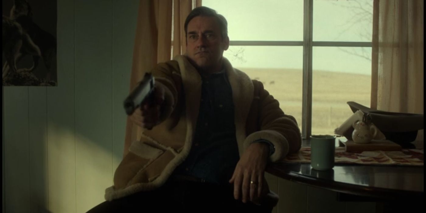 Jon Hamm as Roy Tillman holding a gun and pointing it at someone off-screen in Fargo season 5