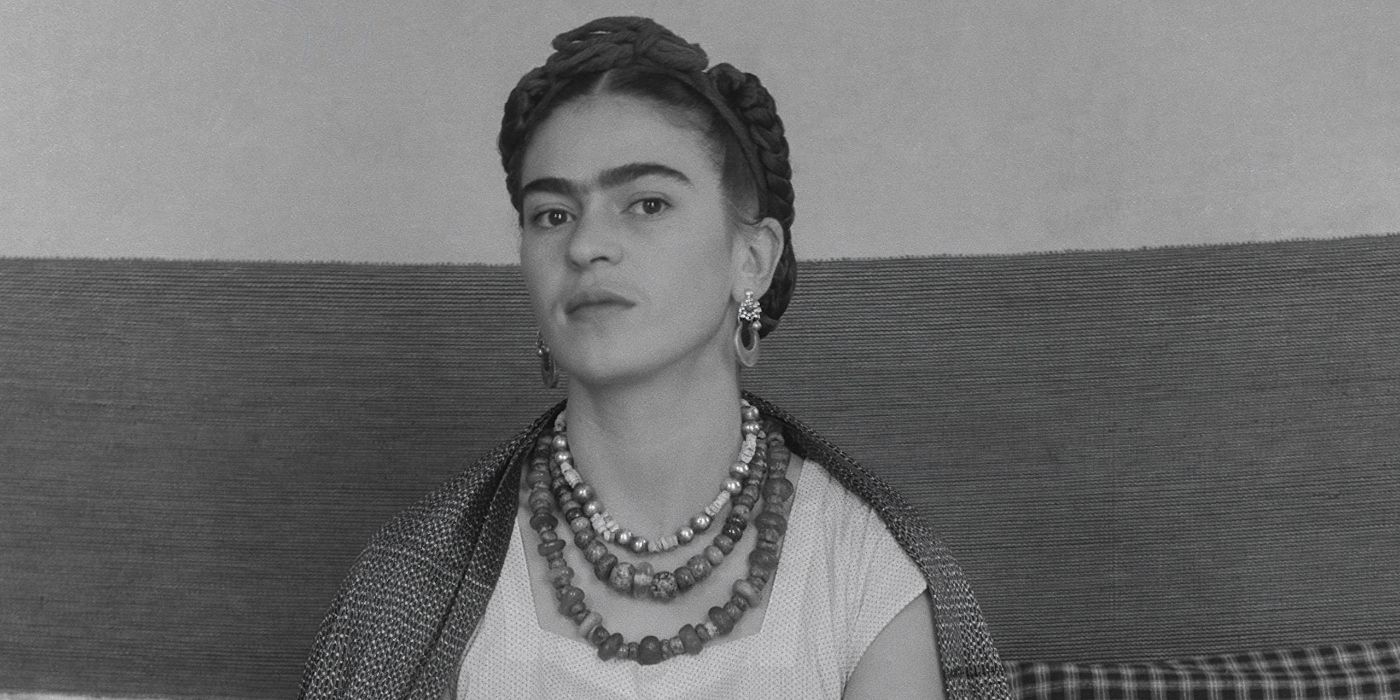 A black and white image of Frida Kahlo posing for a photograph in Frida