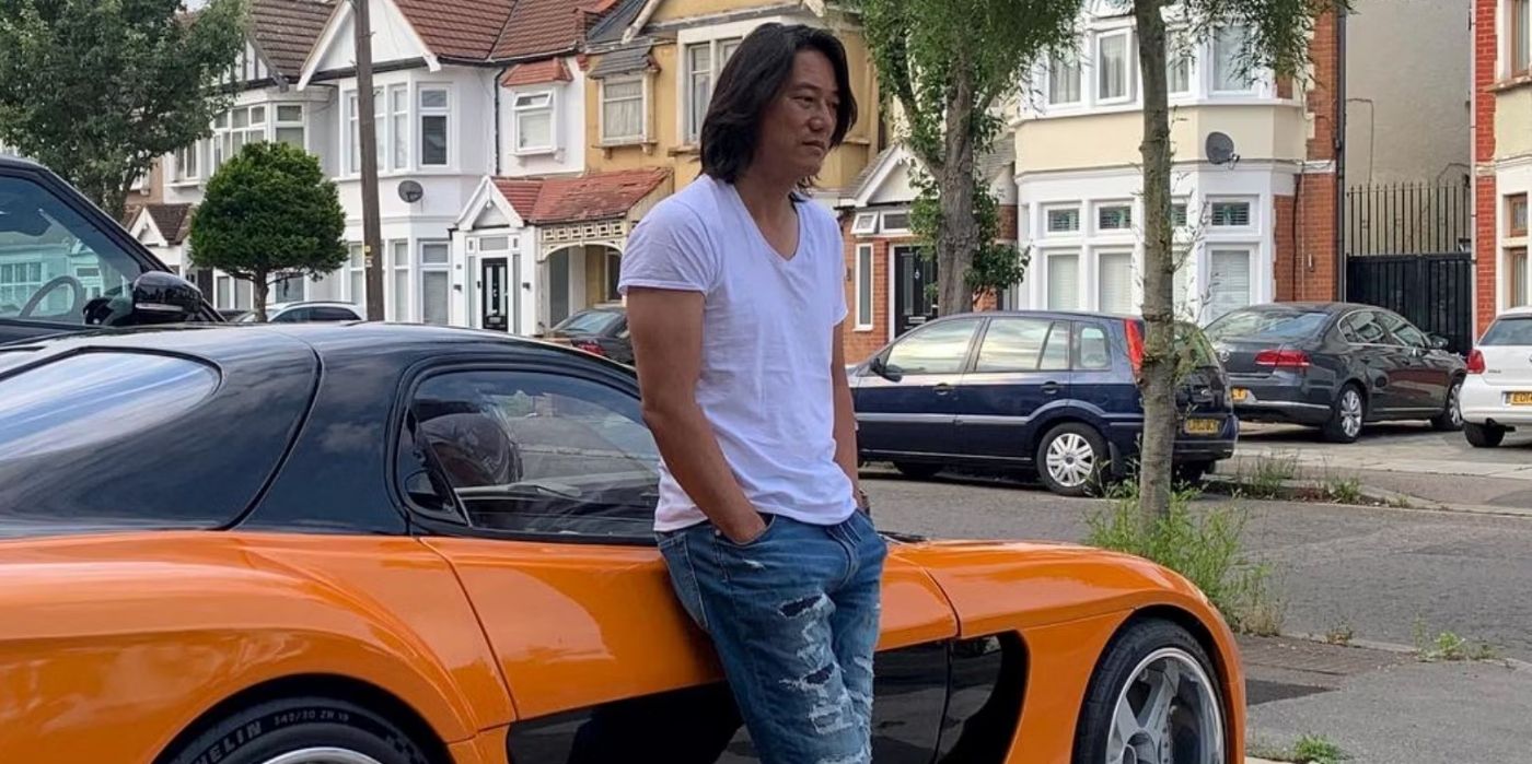 Sung Kang as Han, leaning against a car in Furious 7