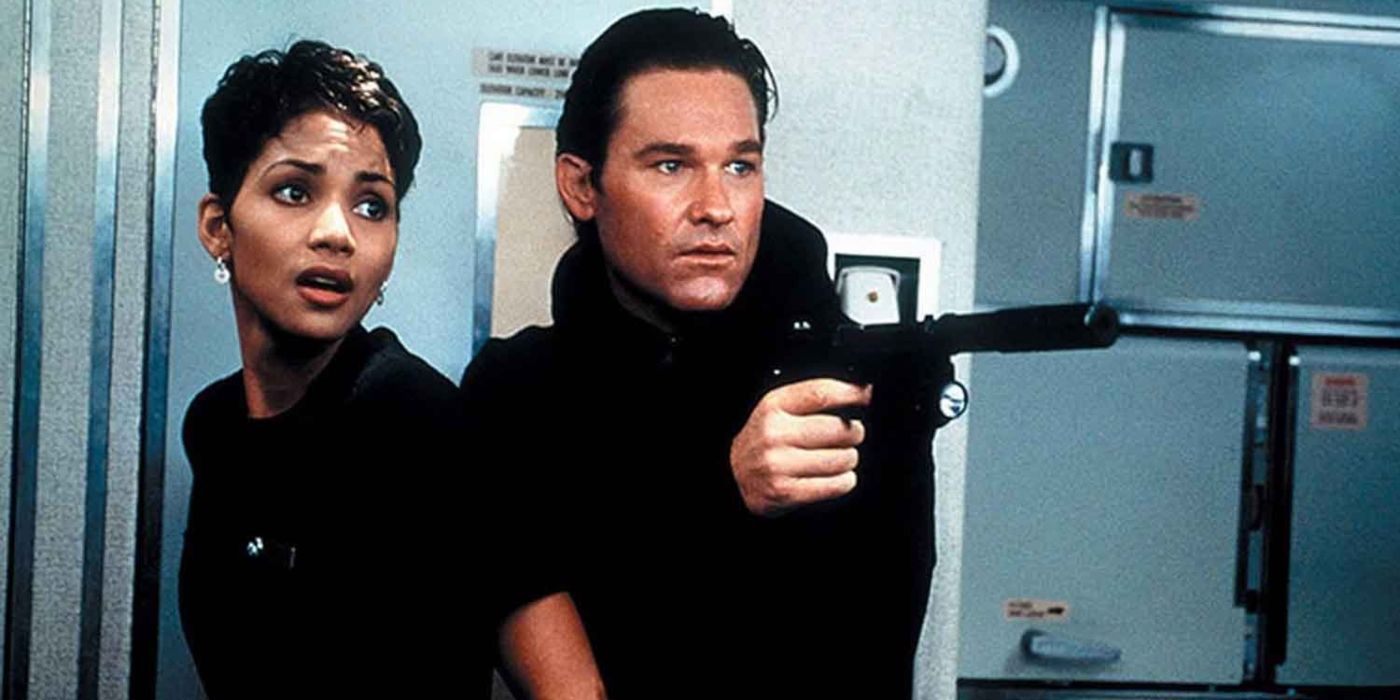 Kurt Russell as Dr. David Grant, armed with a gun, and Halle Berry as Jean, standing in a plane