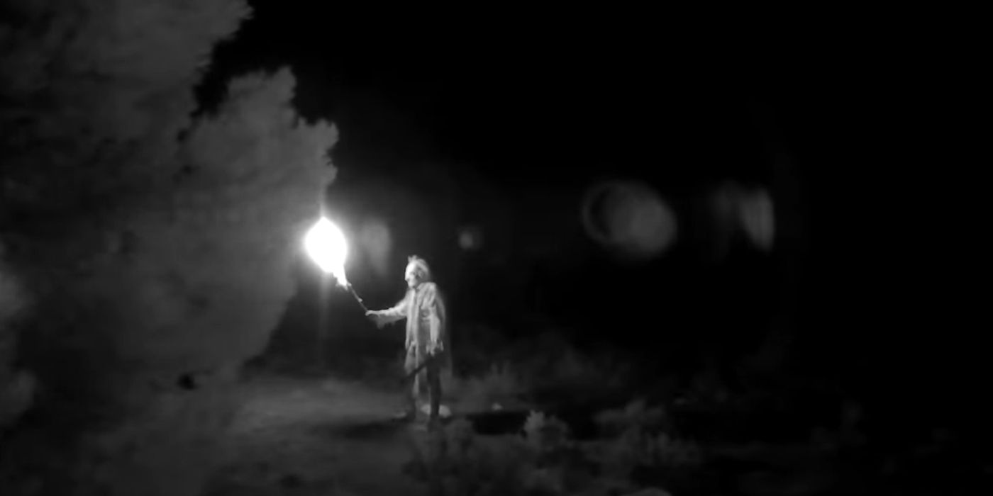 s monstrous figure holds a torch in the film horror in the high desert