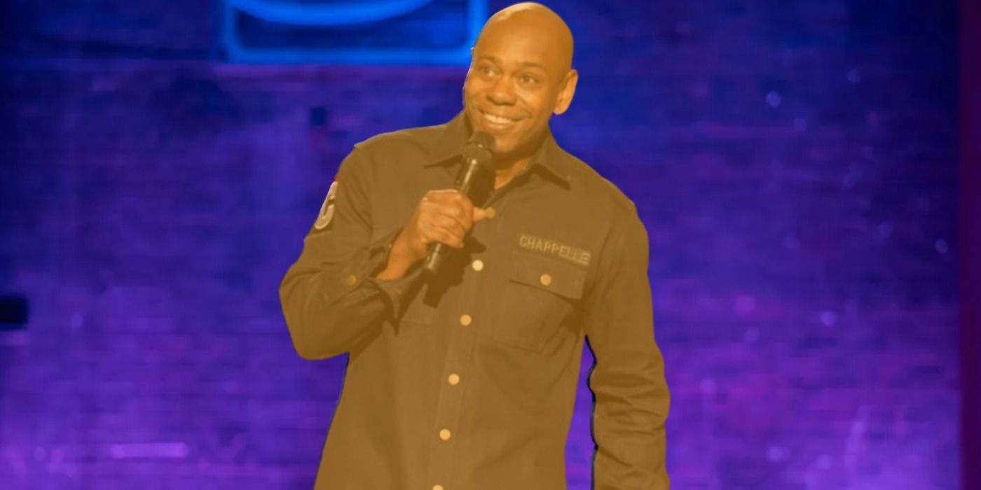 Dave Chappelle in orange performing stand-up in The Dreamer