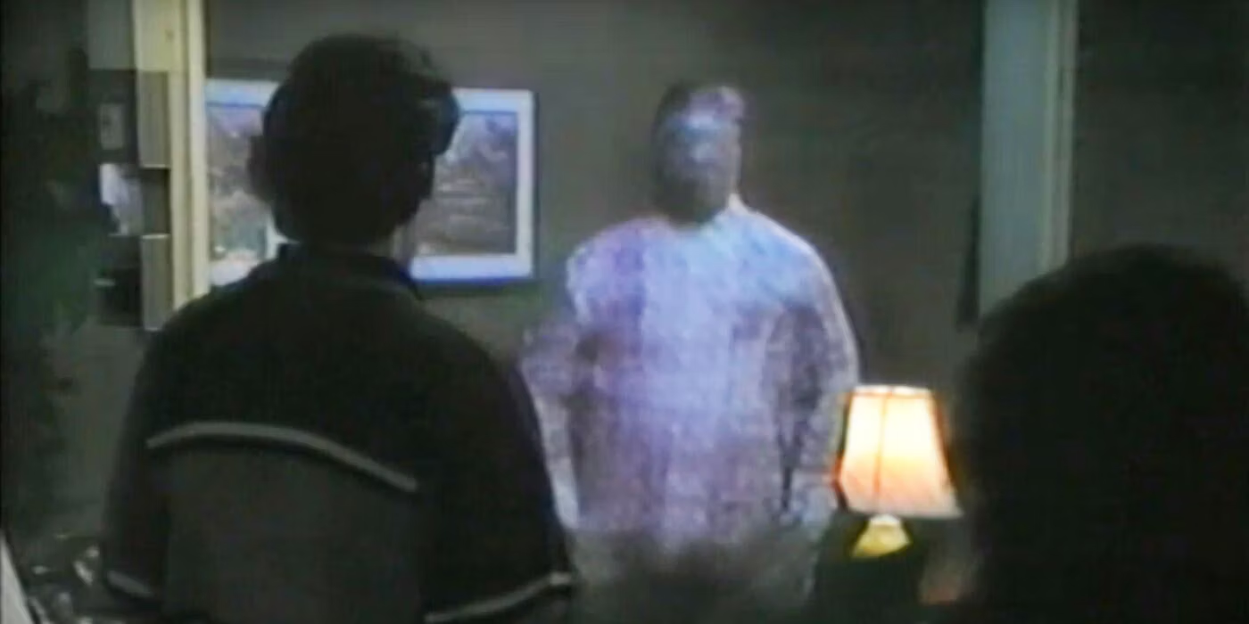 A grainy image of a faceless alien standing in a room of scientists