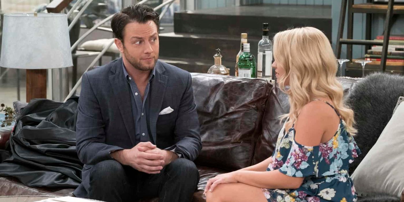 Jonathan Sadowski and Emily Osment as Josh and Gabi sitting on a couch in Young & Hungry