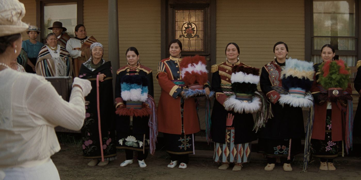 Lily Gladstone as Mollie along with other Native American women in traditional clothing in Killers of the Flower Moon