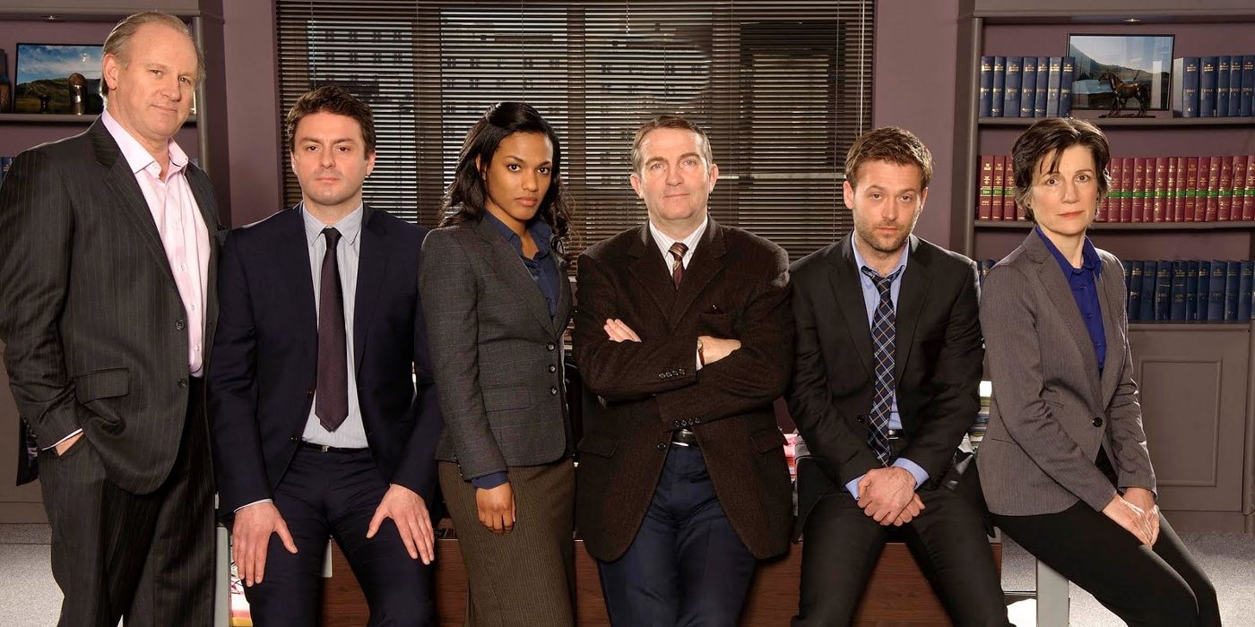 The cast of Law & Order: UK poses in an office