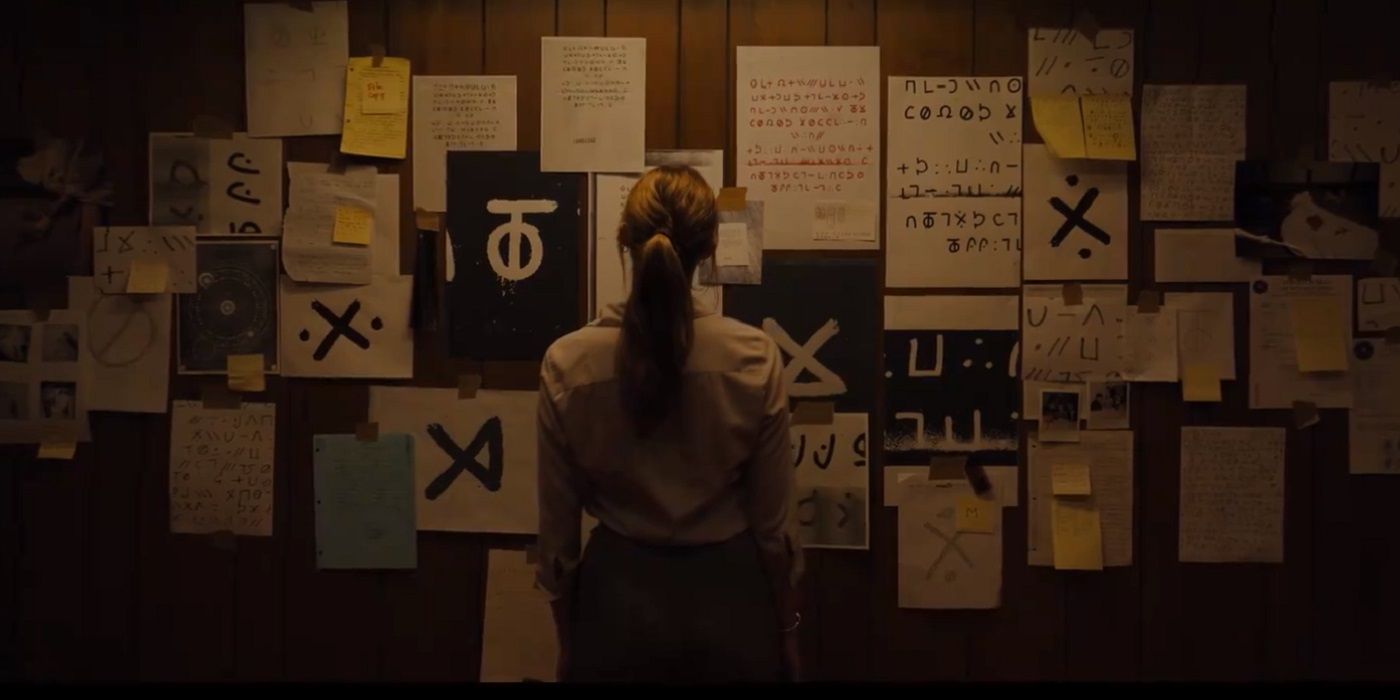 Longlegs movie scene with woman looking at wall covered in cryptic messages