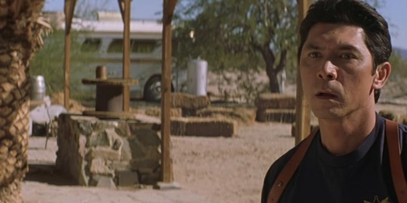 Lou Diamond Phillips as Jack La Roca, standing on a desert property, in Route 666