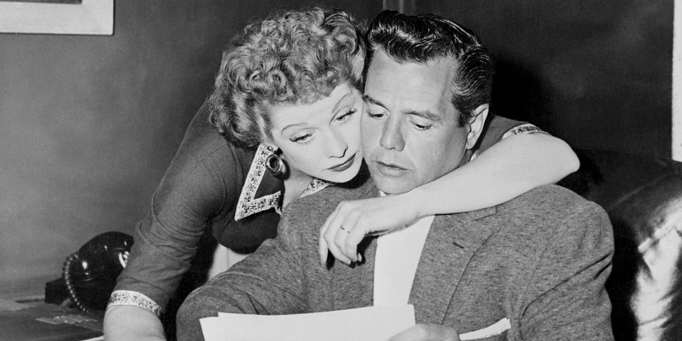 Lucille Ball hugging Desi Arnez from behind in a flashback image from Lucy & Desi.