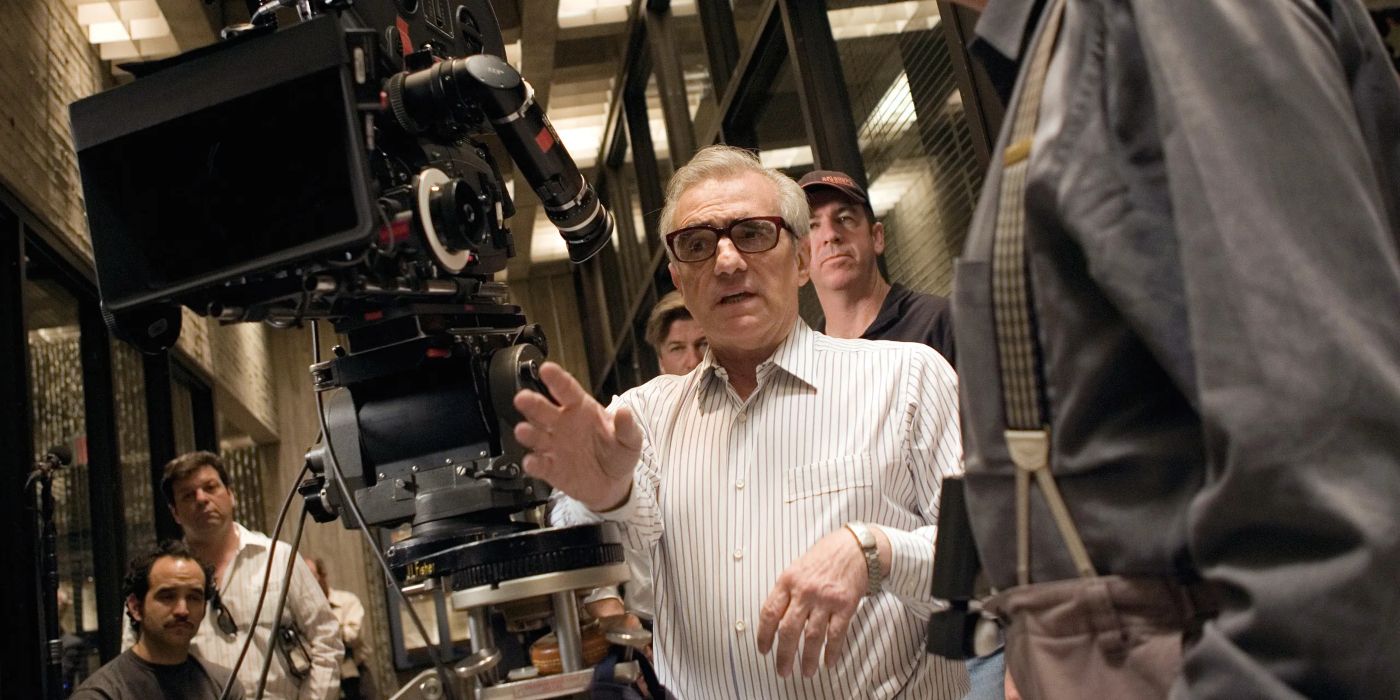 Martin Scorsese wearing a white shirt next to a large camera dircing a movie with crew beside him