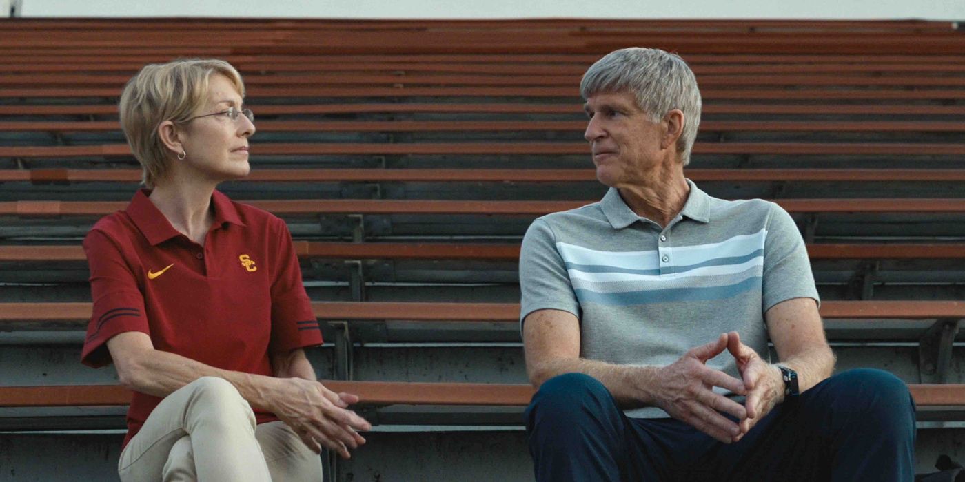 Matthew Modine sits with a woman in the bleachers above the athletic field in Operation Varsity Blues: The College Admissions Scandal (2021).