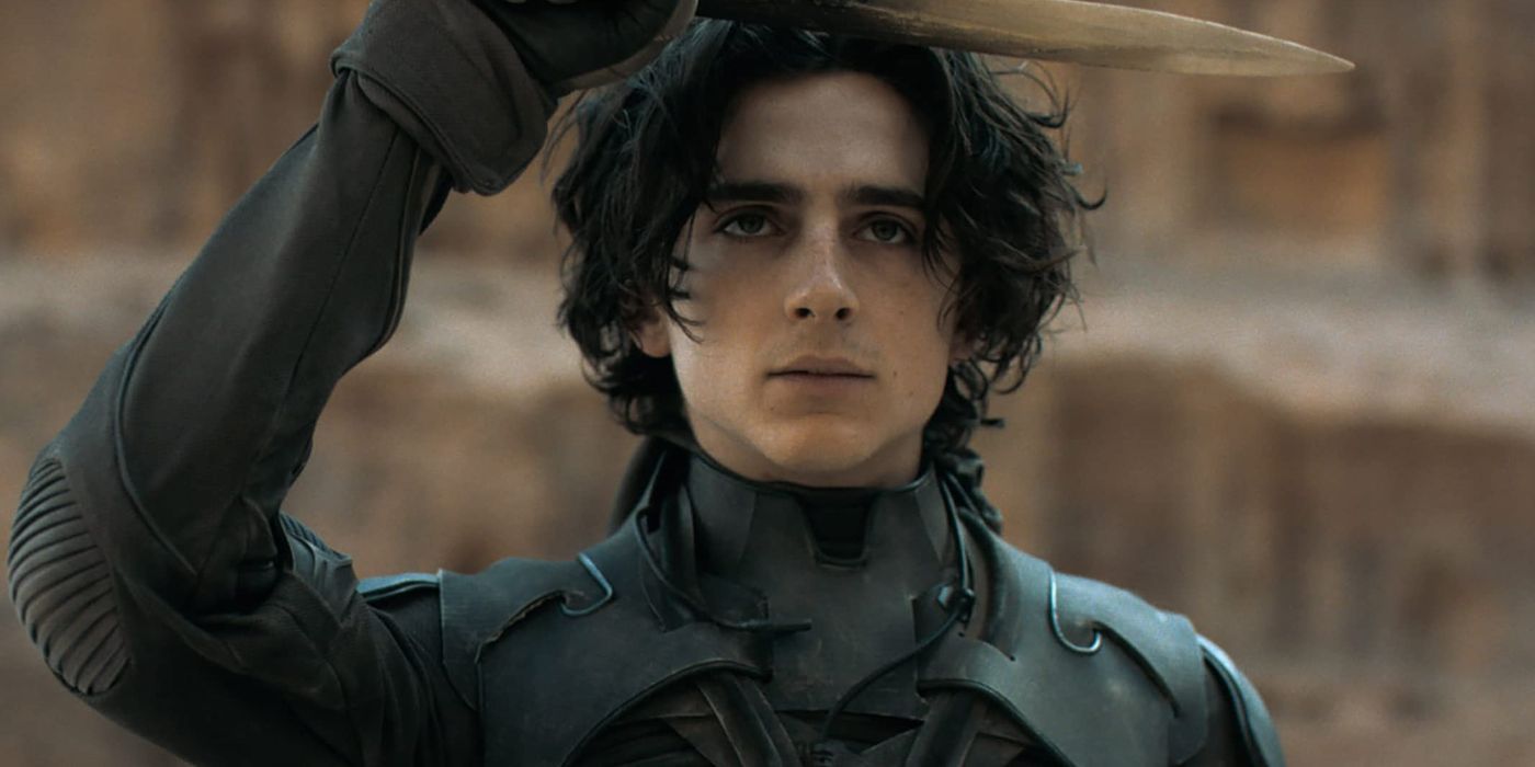 Timothee Chalamet as Paul Atreides, holding a dagger above his head, in Dune