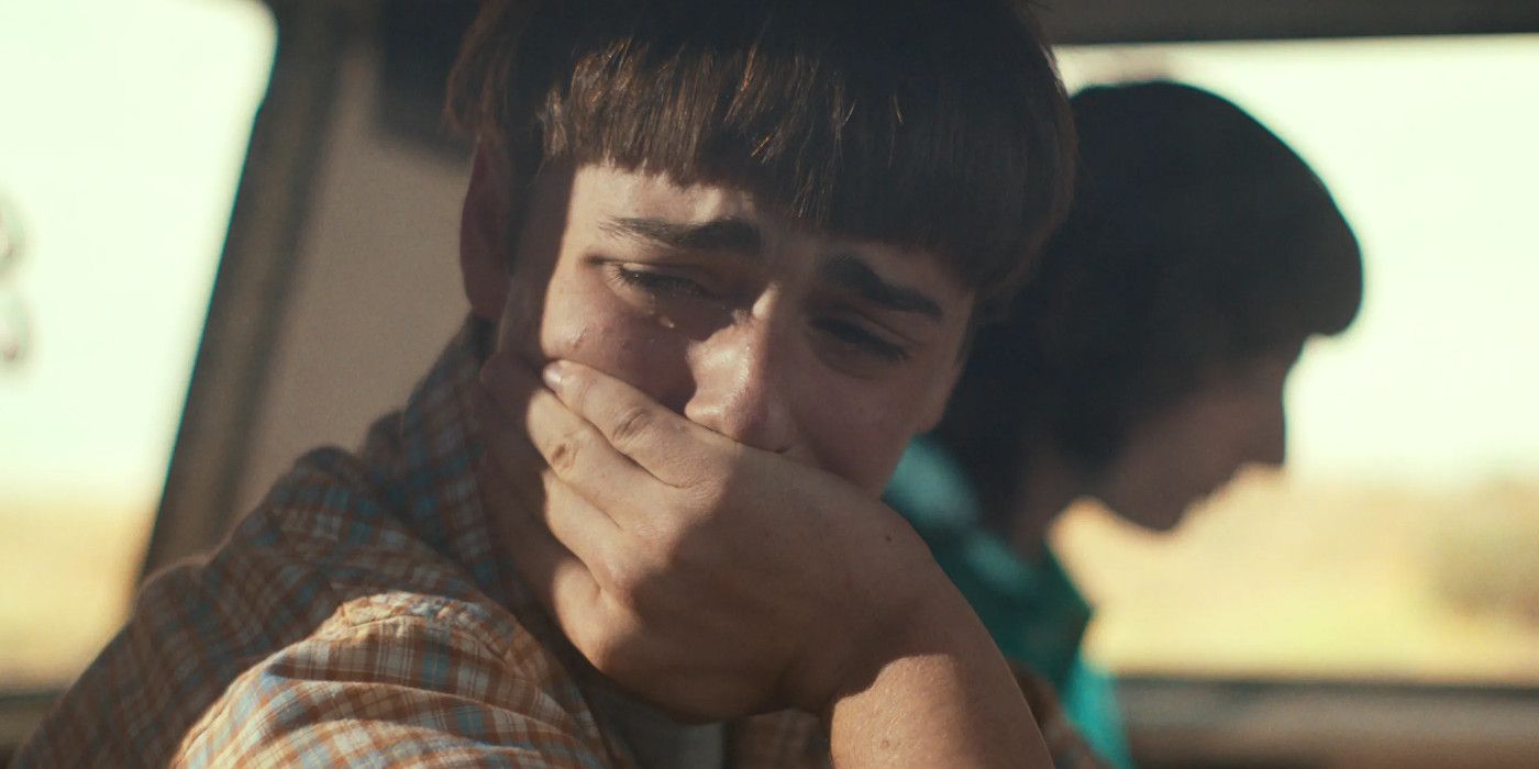 Noah Schnapp as Will Byers in Stranger Things with his hand over his mouth crying.