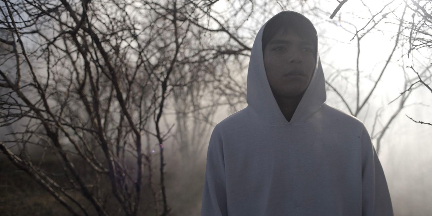Juan Jesús Varela as a teenage Sujo, wearing a hoodie and standing in a foggy forest, in Sujo