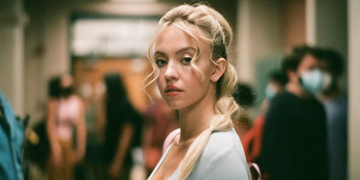 Sydney Sweeney as Cassie all dressed up with make up on in her high school hallway in Euphoria