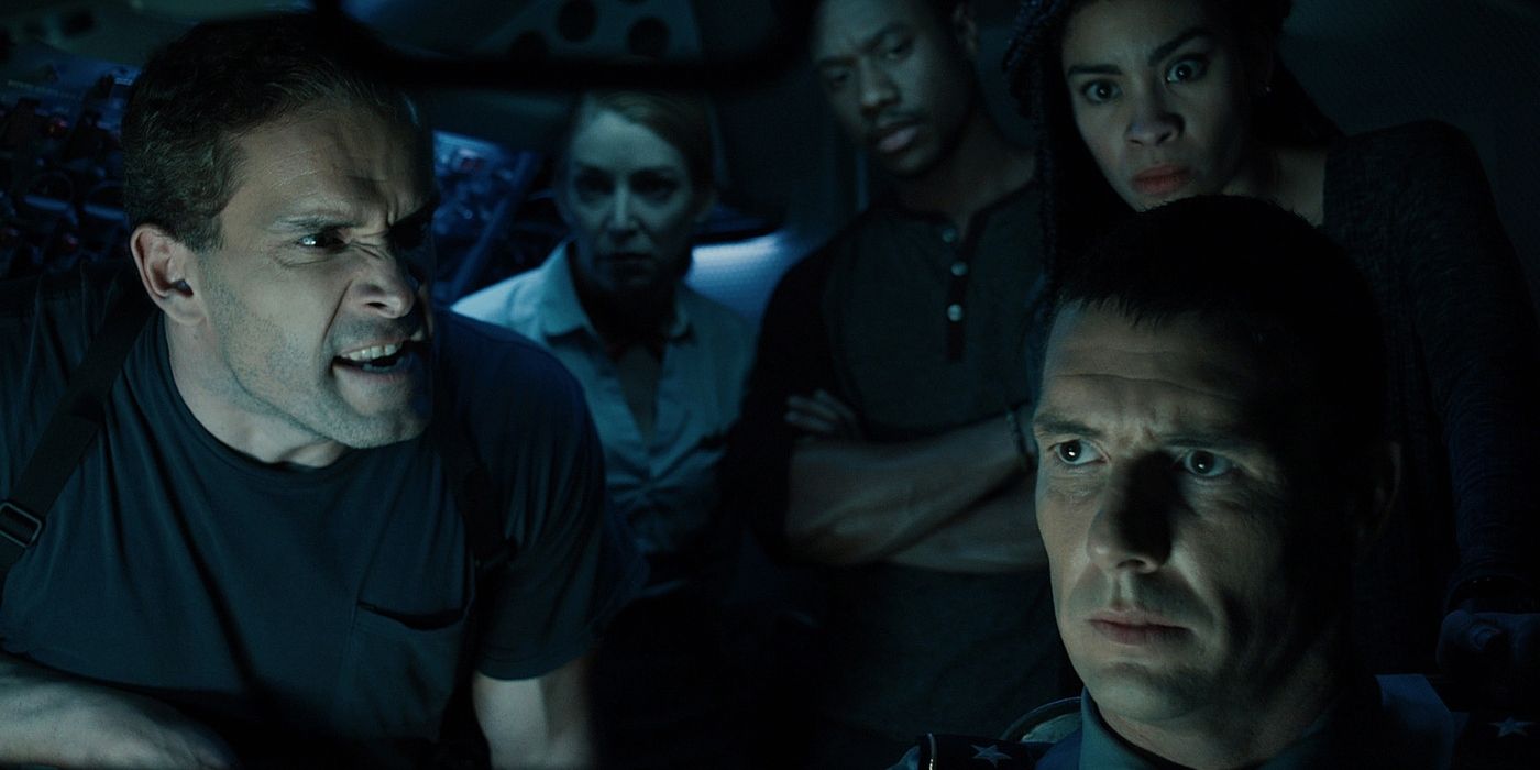 The cast of Flight 666 gather in a small cockpit, lit only by the cool lights of the dashboard