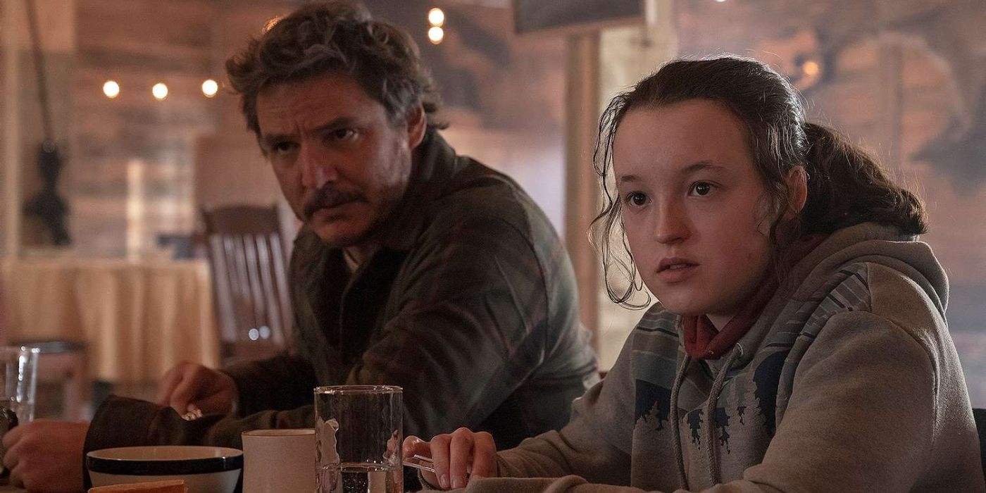 Pedro Pascal as Joel and Bella Ramsey as Ellie eating at a table together in The Last of Us