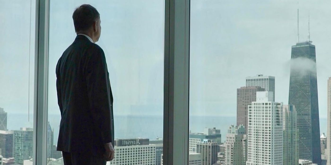 In The Men Who Stole the World (2018), a man stands in front of a window overlooking the Chicago skyline.