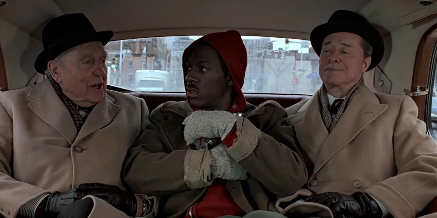 Eddie Murphy as Billy Ray Valentine sits in the back seat of a car between Don Ameche as Mortimer Duke and Ralph Bellamy as Randolph Duke in Trading Places