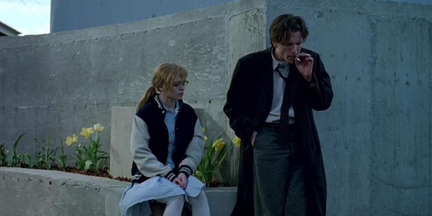 Martin Donovan as Matthew smokes a cigarette while Adrienne Shelly as Maria sits nearby