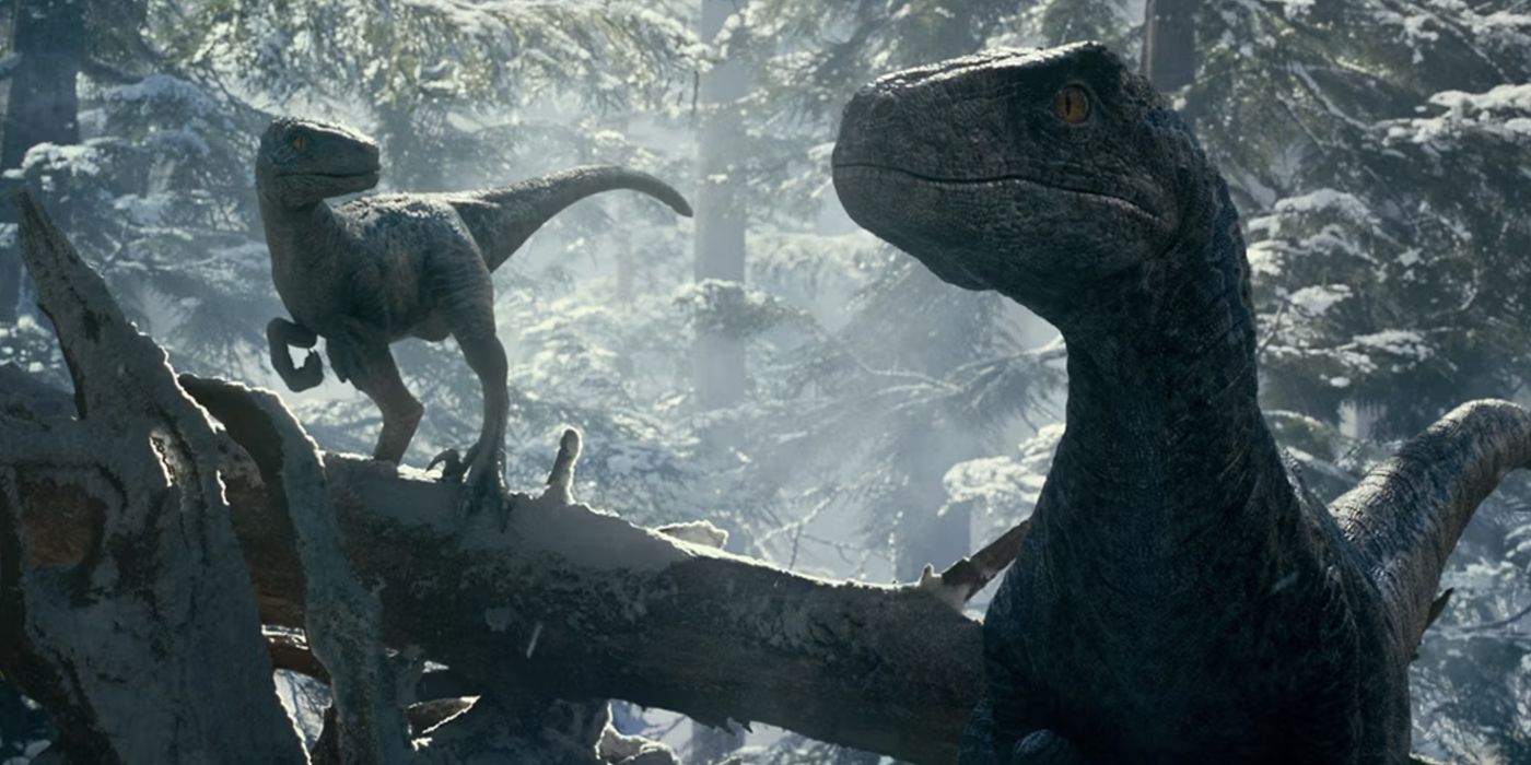 A velociraptor and its baby in the snowy woods in Jurassic World: Dominion