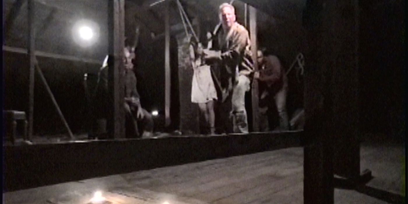 A grainy image of three men in an attic