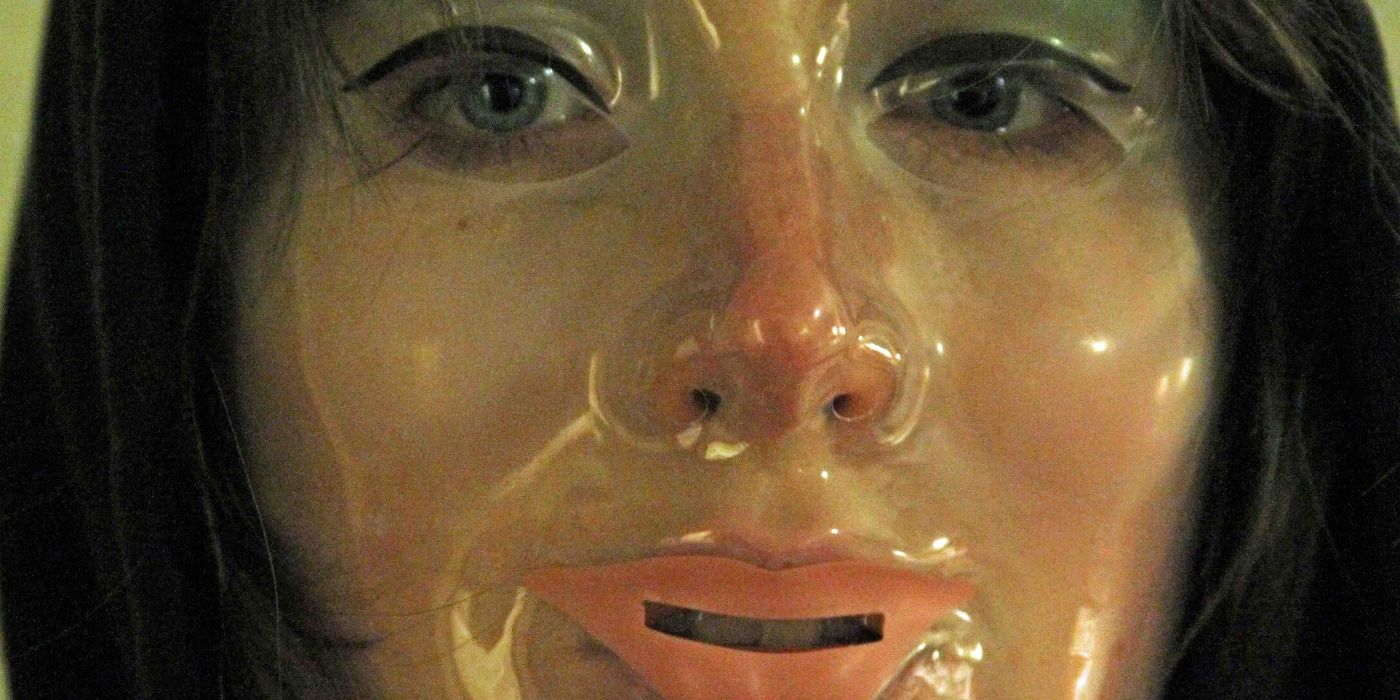 A close-up of Sophia Takal as Stephanie, wearing a clear plastic face mask