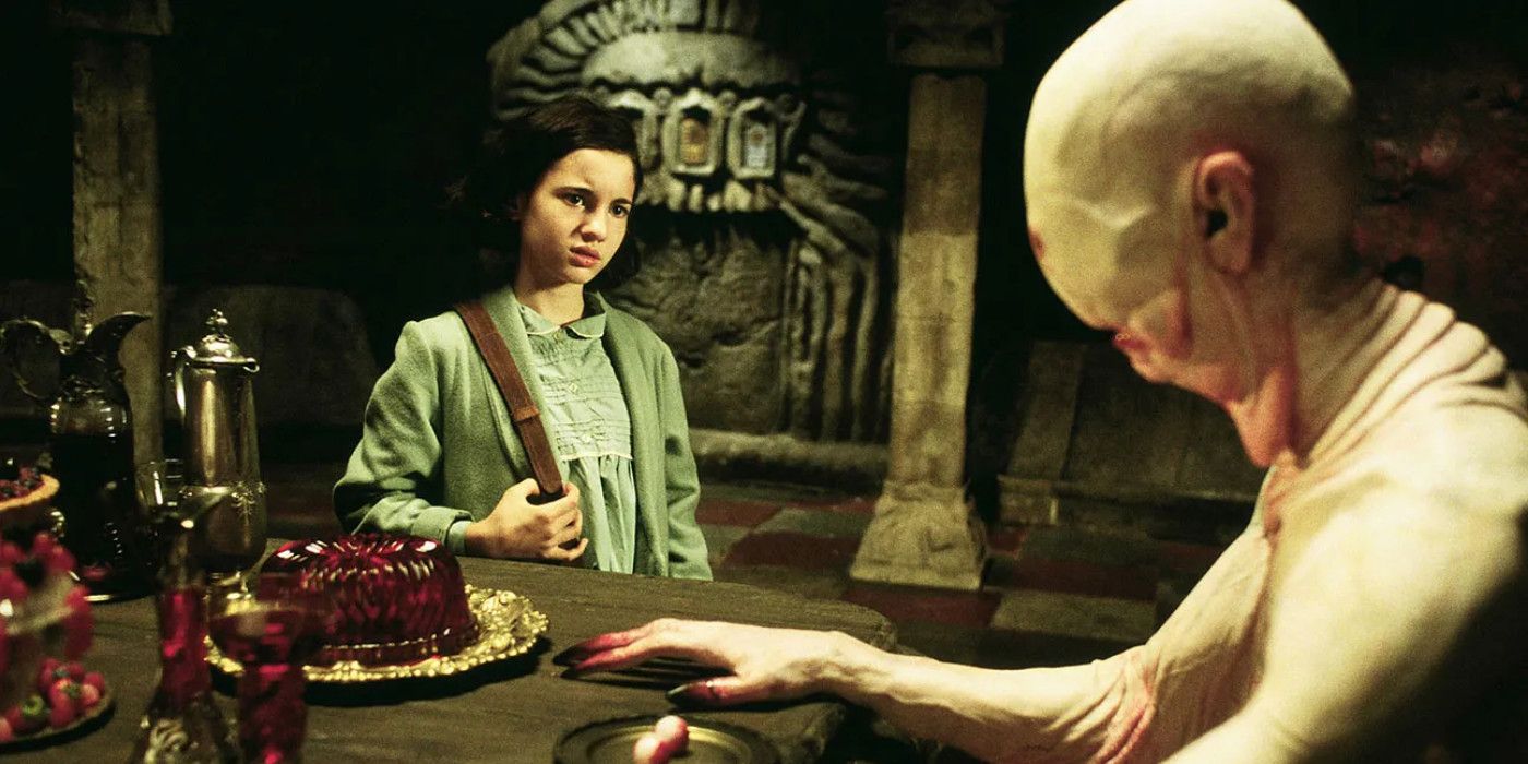 Ivana Baquero as Ofelia stands cautiously by Doug Jone as The Pale Man, who is seated at a dinner table in Pan's Labyrinth